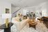 Furnished living room with couch and table with kitchen behind