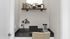 Compact home office nook with beige chair, modern desk, and stylish shelf