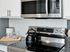 Modern kitchen featuring stainless steel appliances and sleek white cabinetry.