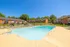 Inviting outdoor pool area with lounge chairs surrounded by apartment buildings and green space.