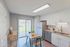 Inviting kitchen with sleek cabinetry, stainless steel appliances, and a cozy dining area set against large sliding glass doors.