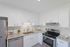 Bright modern kitchen with sleek white cabinetry, granite countertops, stainless steel appliances, and subway tile backsplash.