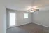 Bright bedroom with plush carpeting, a ceiling fan, and a door leading to outdoor access.