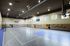 Spacious indoor sports court with basketball hoop, volleyball net, and branded wall pads at Timberline Place.