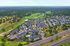 Aerial view of a picturesque residential community surrounded by lush greenery and open spaces.