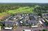 Aerial view of a lush residential community surrounded by greenery and a golf course.