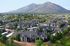 Aerial view of a charming residential community surrounded by lush greenery and mountains.