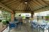 Inviting outdoor patio area featuring a covered gazebo, stone fireplace, grill, and seating for relaxation.