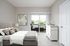 Modern bedroom with stylish decor, plush gray bed, abstract art, and a view of the outdoor patio.