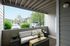 Inviting outdoor patio with cozy seating, elegant decor, and lush greenery in a modern apartment complex.