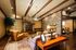 Inviting rustic living room with stone fireplace, elegant wooden beams, and plush seating.