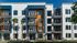 Stylish multi-story apartment complex with modern balconies and palm trees enhancing the fa&ccedil;ade.