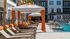 Elegant pool area with sun loungers and orange-accented cabanas in a modern apartment complex.