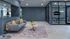 Contemporary lounge area with a stylish gray sofa, decorative pillows, unique lighting, and a glass-walled meeting room.