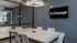 Modern meeting room with sleek table, chairs, and glass walls under a contemporary chandelier.