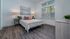 Cozy bedroom with modern decor, featuring a comfortable bed, soft lighting, and large windows with blinds.