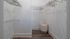 Modern walk-in closet featuring ample hanging space with wire racks and wooden flooring.