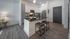 Sleek kitchen with modern appliances, island seating, and elegant gray cabinetry.