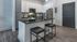 Sleek kitchen with a modern design, featuring white cabinets, stainless steel appliances, and a stylish black granite island.