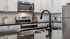 Chic modern kitchen with stainless steel appliances, black granite countertop, and white cabinetry.