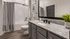 Chic bathroom featuring a granite countertop, modern fixtures, and subway tile walls.