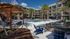 Stunning outdoor pool area with palm trees, lounge seating, and modern apartment complex in the background.