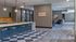 Sleek kitchen and lounge featuring modern lighting, stylish bar stools, and a comfortable seating area.