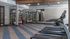 Modern fitness center with treadmills, workout equipment, and mirrored walls.