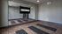 Contemporary fitness studio with sleek wooden flooring, wall-length mirror, and yoga mats, ideal for personal workouts.