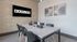 Modern meeting room with a large table, stylish chairs, and elegant wall art, featuring a screen with 'BARLOW' displayed.