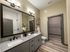 Contemporary bathroom with double sinks, granite countertop, and walk-in closet.