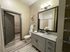Modern bathroom with stylish cabinetry, large mirror, and granite countertop featuring a floral decoration.