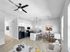 Sleek modern kitchen and dining area with stylish living room, featuring light wood flooring and chic decor.