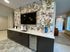 Modern kitchenette featuring a stylish marble countertop and vibrant floral tile backsplash.