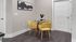 Cozy dining area with a round glass table and stylish yellow chairs.
