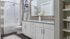 Elegant bathroom featuring modern dual sink vanity, granite countertops, and stylish decor.