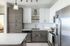 Sleek modern kitchen with stainless steel appliances, white cabinets, and a quartz countertop island.