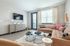 Bright and stylish living room featuring a comfortable L-shaped sofa, modern decor, and a wall-mounted TV.