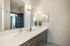 Modern bathroom with double sinks, sleek cabinetry, and stylish lighting.
