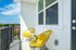 Charming balcony with two bright yellow chairs and a small table, offering a relaxing outdoor space with a view.