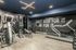 Modern apartment gym with exercise machines and motivational decor.
