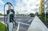 Modern apartment complex featuring an electric vehicle charging station in a spacious parking area.