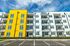 Colorful modern apartment building with striking yellow facade and multiple balconies.