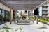 Inviting outdoor patio with a cozy fireplace, modern seating, and decorative pergola.