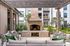 Cozy outdoor patio with a brick fireplace and comfortable seating under a wooden pergola.