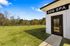 Modern dog spa featuring a lush outdoor play area under a clear blue sky.
