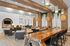Luxurious communal lounge featuring wooden beams, modern seating, and ambient lighting.