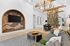 A stylish living room with a decorative wall, modern chandelier, and open dining area.