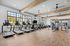 Spacious gym with modern exercise equipment, featuring treadmills, elliptical machines, and weight stations.