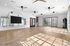 Bright and airy gym studio featuring wooden floors, modern ceiling fans, and large windows.